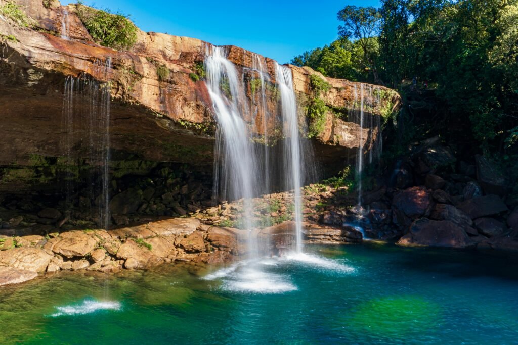 A breathtaking panoramic view of a tropical lagoon with turquoise water, lush green mountains, and a bright blue sky.